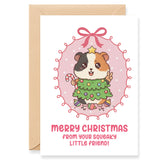 Christmas card with a guinea pig holding a Christmas tree and candy cane, surrounded by festive decorations.